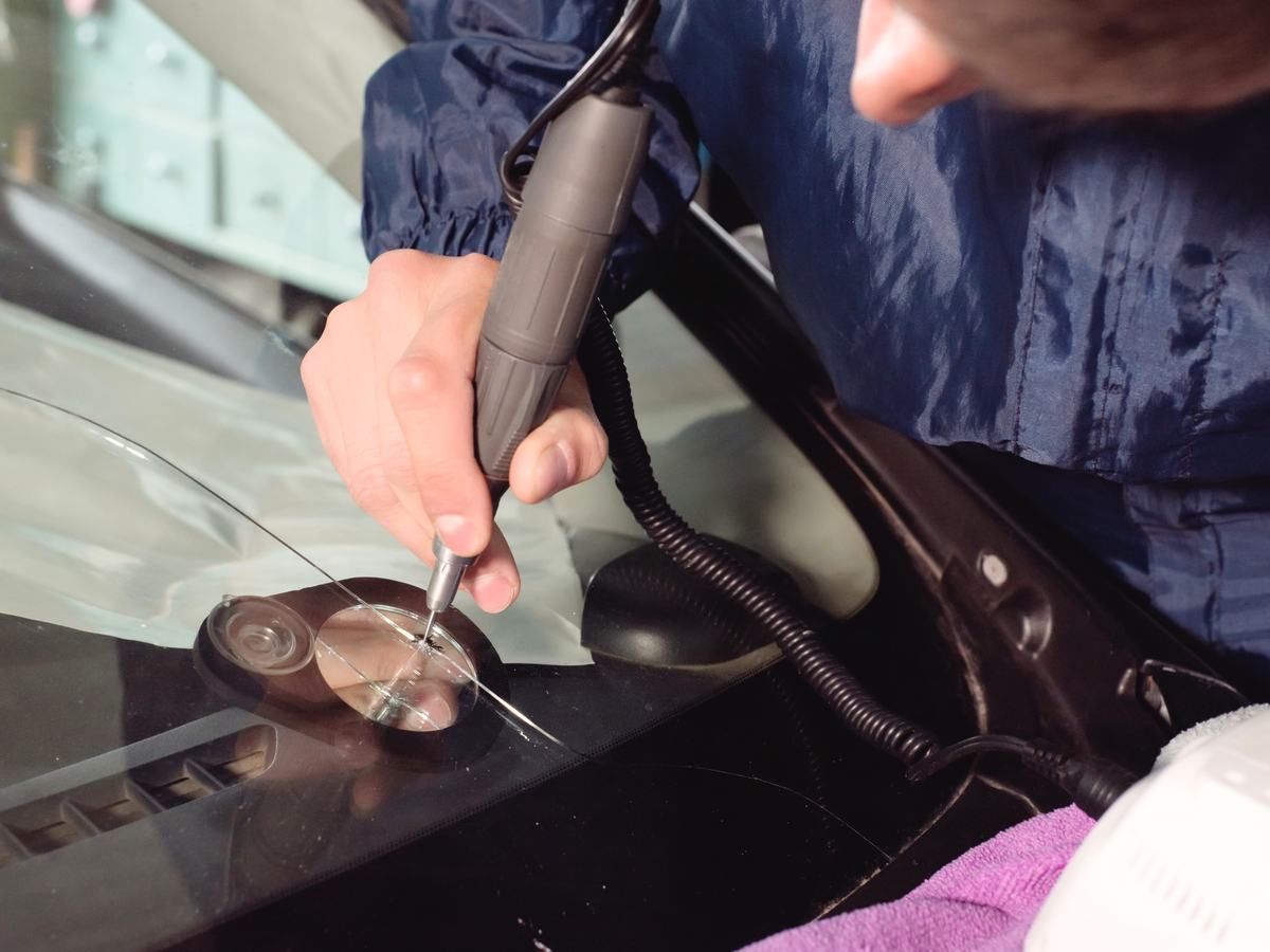 Autoglaser arbeitet an einer beschädigten Fahrzeugscheibe