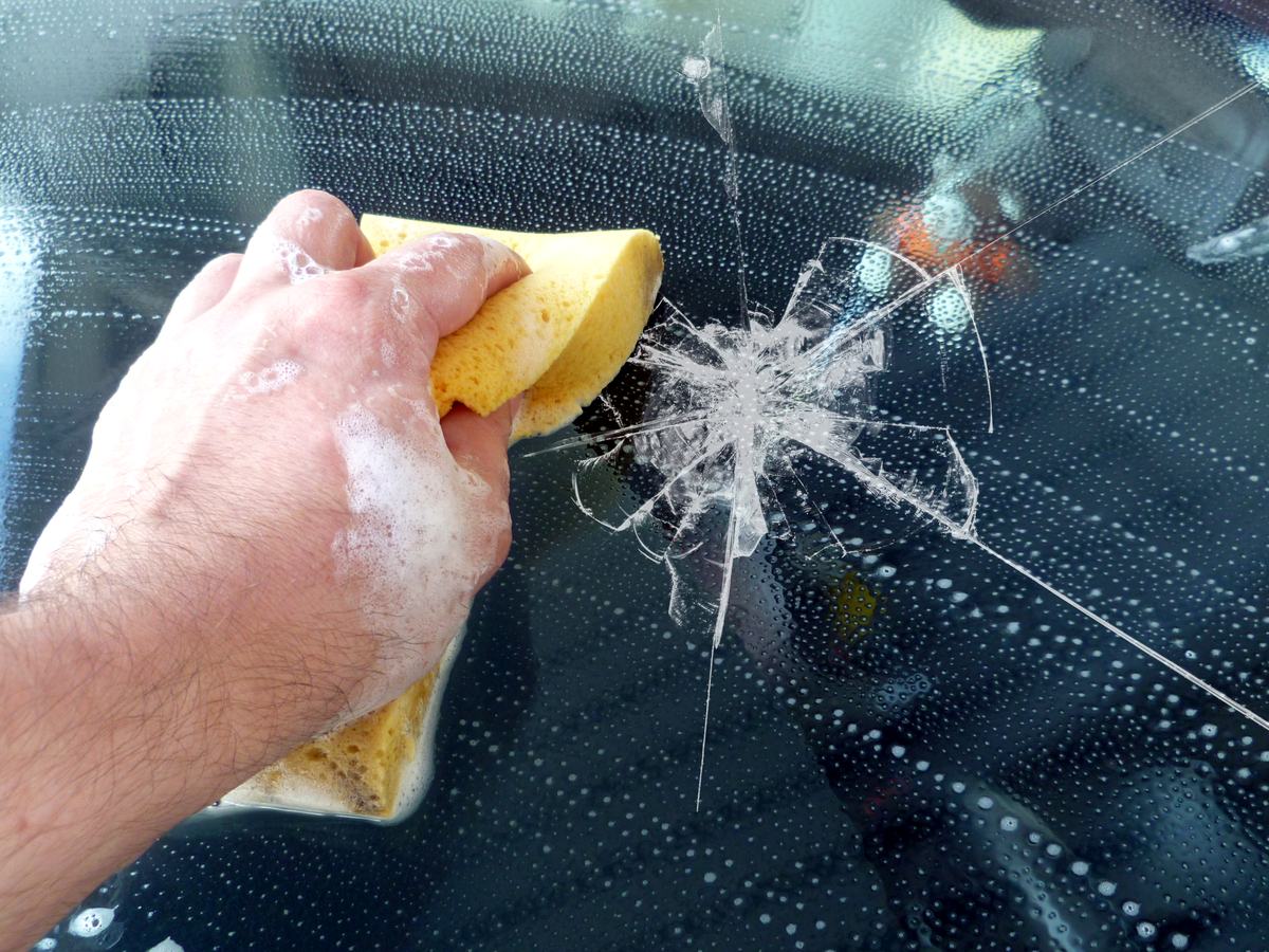 Beschädigte Fahrzeugscheibe mit großem Einschlag